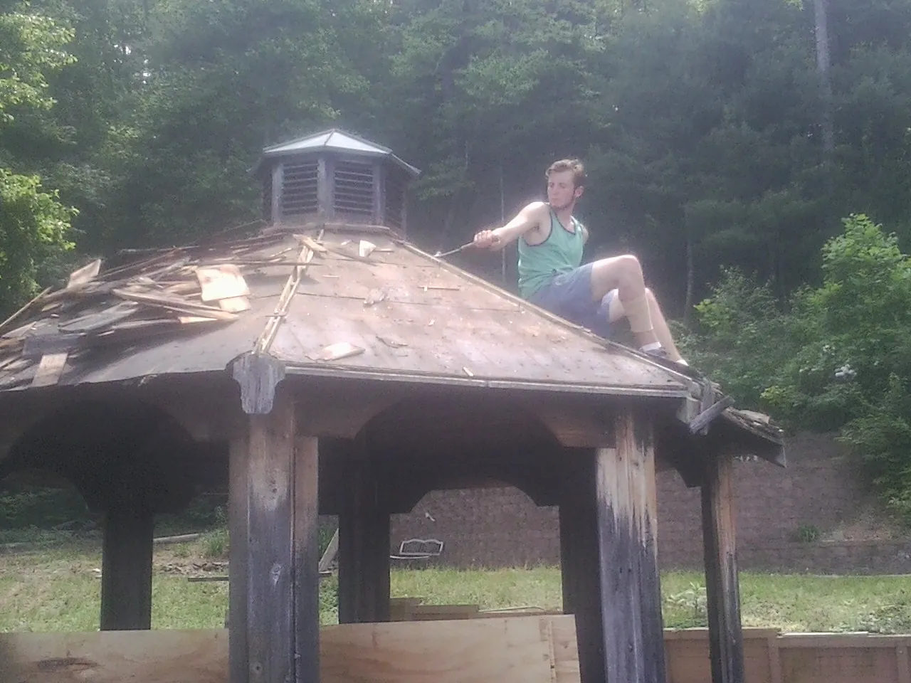 Tearing the old roof off a wooden gazebo before new shakes in Sumpter
