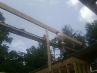 Carpenter setting a ridge beam over a new addition frame — Ice Dam Removal by Roofing Brothers in Sumpter