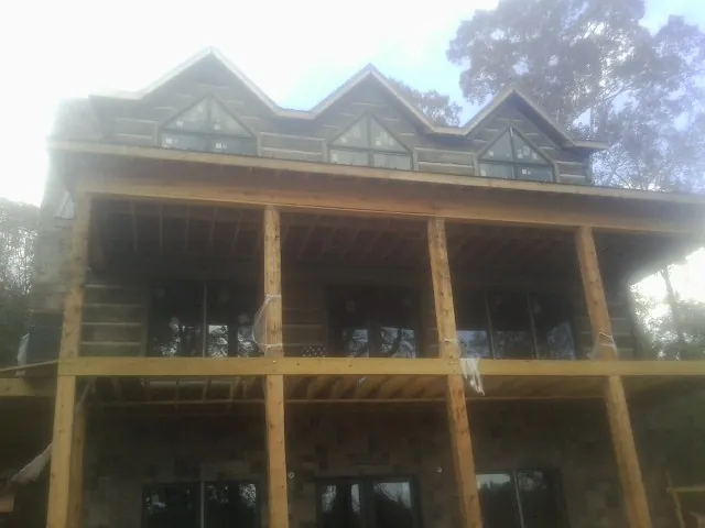 Dormers and porch framing on a large log home under construction — Roof Coating work by our crew in Sumpter
