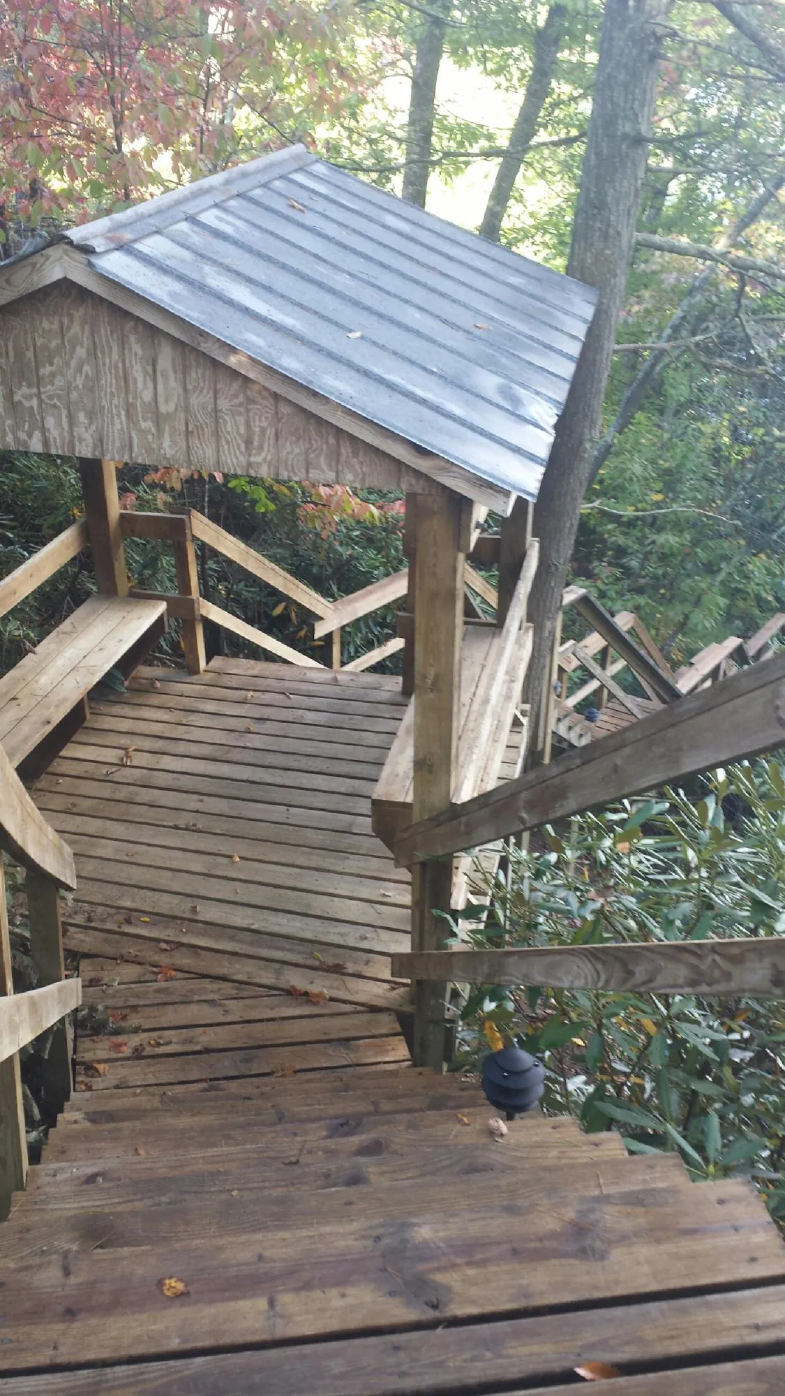Metal roofed shelter over wooden steps on a wooded walkway — Skylight Repair & Installation work by our crew in Sumpter